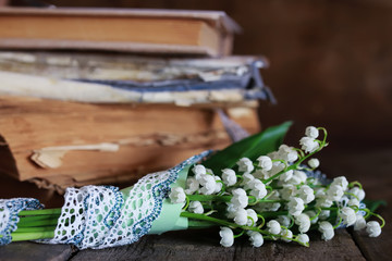 bouquet of fresh lilies of the valley and retro book