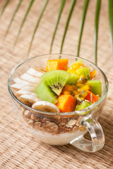 Breakfast with muesli, yoghurt, tropical fruits