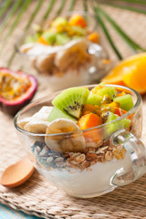 Breakfast with muesli, yoghurt, tropical fruits