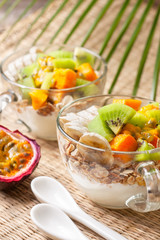 Fototapeta na wymiar Breakfast with muesli, yoghurt, tropical fruits