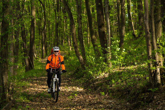 Cyclist Riding the Bike on a Trail in Summer Forest