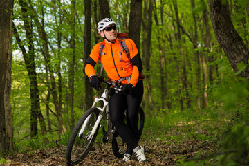 Cyclist Riding the Bike on a Trail in Summer Forest