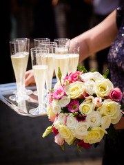 Brautstrauß und Sektgläser glänzen im Sonnenlicht