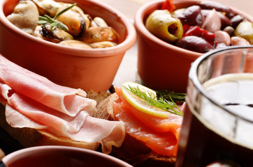 Tapas of salmon, mussels, jamon and olives with beer