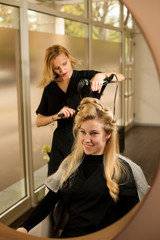 professional hair stylist at work - hairdresser  doing hairstyle