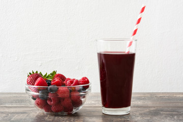 Berries smoothie in a glass on wood