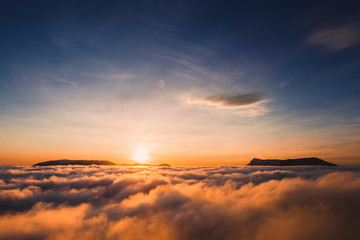 Beautiful sunset on the hill above clouds