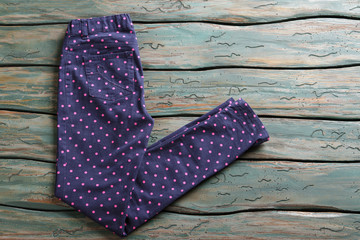 Dark navy pants. Dotted trousers on wooden background. Woman's pants with simple print. Brand new clothes on auction.