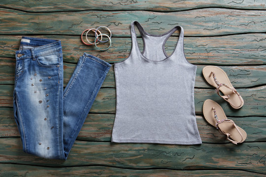 Jeans and gray tank top. Blue denim pants and sandals. Woman's brand new stylish jeans. New arrivals in brand shop.