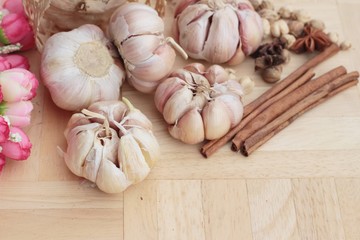 Garlic  has health benefits on wood background.