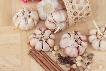 Garlic  has health benefits on wood background.