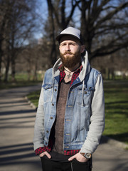 Stylish hipster model with hat and beard. Lifestyle in the park