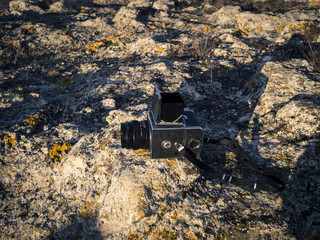 Close up of vintage camera on rocks. Old 6x6 russian camera. Lomography.