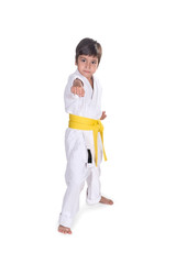 the boy stands in white kimono of the karateka with a yellow bel