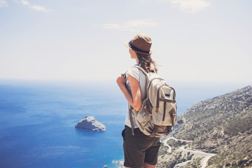 Back side of traveler girl looking at the sea, travel and active lifestyle concept