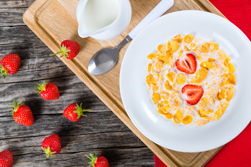 corn flakes wirh milk and strawberries, top view