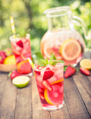 Pink lemonade with lemon, lime and strawberries 
