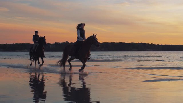 Two Riders on Horses at Beach in Sunset Light. Shot on RED Cinema Camera.