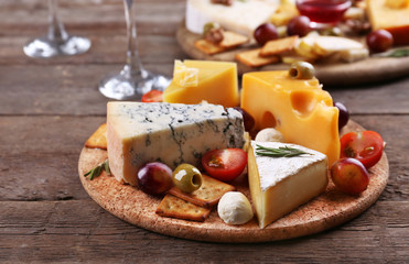 Different kinds of cheese on wooden background