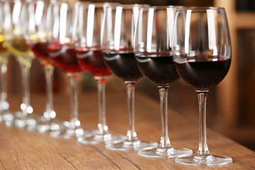 Many glasses of different wine in a row on bar counter