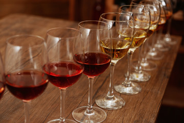 Many glasses of different wine in a row on bar counter