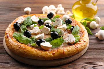 Delicious tasty pizza with ingredients on wooden table