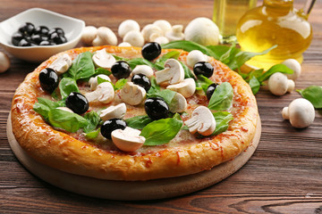 Delicious tasty pizza with ingredients on wooden table