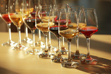 Many glasses of different wine in a row on a table