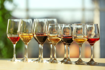 Many glasses of different wine in a row on a table