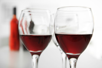 Glasses of red wine on white table closeup