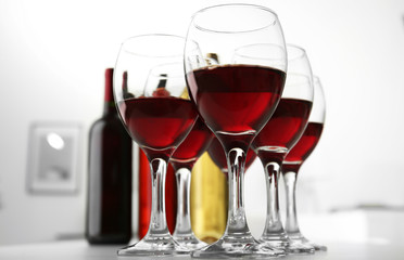 Glasses of red wine on white table closeup