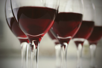 Glasses of red wine on white table closeup