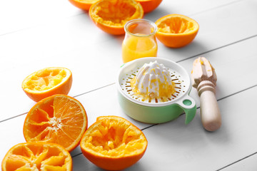 Juicing delicious oranges on white wooden table