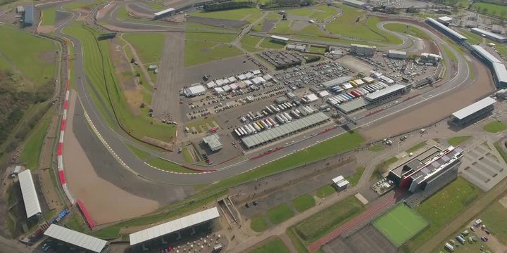 Aerial view of  a big  race on a sunny summer  day in England.  Cars going along the race. Full campsite.