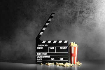 Clapper board and pop corn on wall background