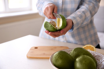Woman cutting fresh avocado in kitchen © Africa Studio