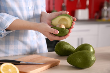 Woman holding fresh avocado in kitchen © Africa Studio