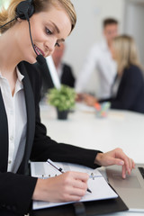 Fototapeta premium Portrait of a smiling creative businesswoman with earpiece in office..