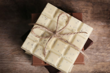 Different chocolate bars on wooden background