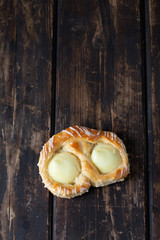 Puddingschnecke, Kuchen, Pudding, Zuckerguss, dunkler Holzunterg