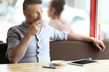 Businessman resting with cup of coffee in cafe