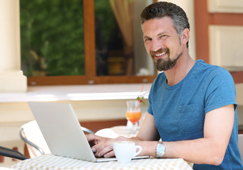 Businessman working with laptop in cafe
