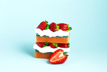 Sponge cake / Creative concept photo of a strawberry cake made of sponges on blue background.