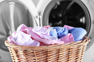 Baby clothes and washing machine, close up