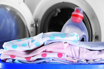 Baby clothes and washing machine, close up