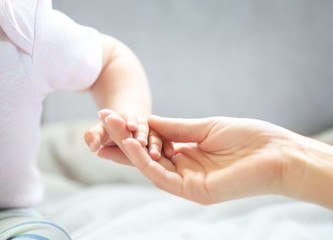 Woman holding small baby hand