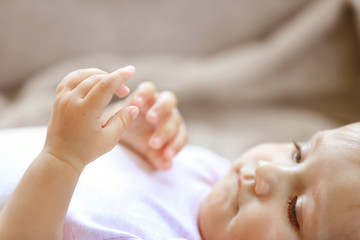 Cute small baby girl on grey couch