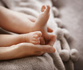 Woman holding small baby feet