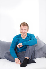Fototapeta premium Junger Mann sitzt auf Couch, entspannt, relaxed, Freizeit