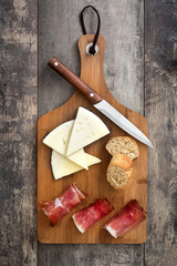 Spanish serrano ham, cheese and sausage on a rustic wooden background
